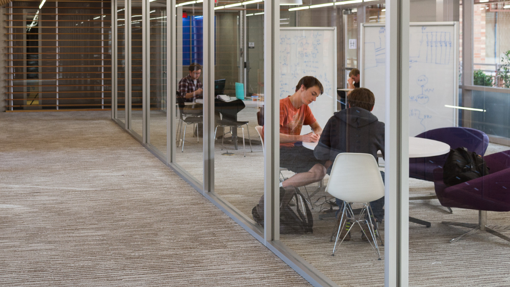 Students studying on the 3rd floor atrium bridge with Computing Across Disci