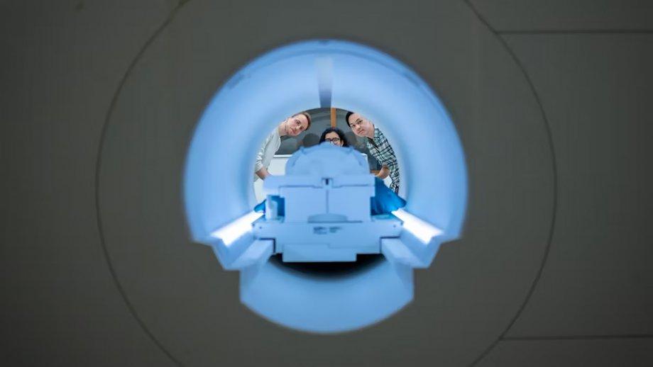 Alex Huth (left), Shailee Jain (center) and Jerry Tang (right) prepare to collect brain activity data in the Biomedical Imaging Center at The University of Texas at Austin. The researchers trained their semantic decoder on dozens of hours of brain activity data from participants, collected in an fMRI scanner. Photo Credit: Nolan Zunk/University of Texas at Austin.