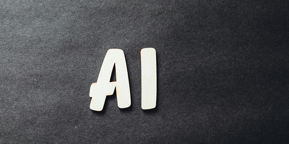 Letters &#039;AI&#039; in sans serif font against charcoal gray felt textured background