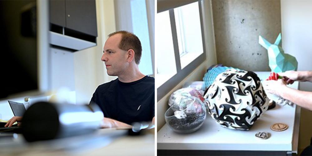 Etienne Vouga sitting at his desk in his office at GDC, wearing a black t-shirt and facing his computer.