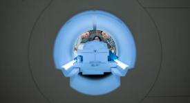 Alex Huth (left), Shailee Jain (center) and Jerry Tang (right) prepare to collect brain activity data in the Biomedical Imaging Center at The University of Texas at Austin. The researchers trained their semantic decoder on dozens of hours of brain activity data from participants, collected in an fMRI scanner. Photo Credit: Nolan Zunk/University of Texas at Austin.