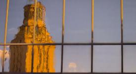 The University of Texas at Austin tower reflected in glass building