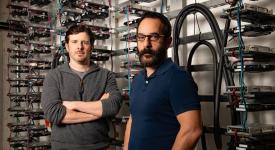 Alex Demarkis, right, and Adam Klivans, left, in front of the GPU computing cluster powering the Center for Generative AI.