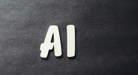 Letters &#039;AI&#039; in sans serif font against charcoal gray felt textured background