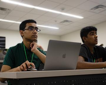 Two students working hands-on to build their robot in the robotics lab on UT Campus