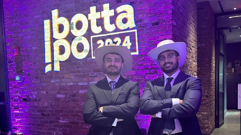 Sriram Hariharan and business partner in cowboy hats in front if Ibotta IPO 2024 sign, celebrating their Chrome Extension, InStock being acquired by Ibotta.