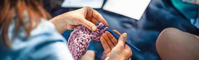 over shoulder view of person crocheting with lavender yarn